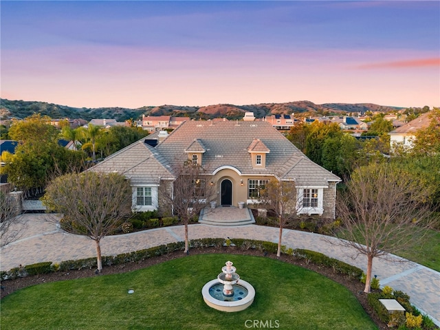 19103 Green Oaks Rd, Yorba Linda, CA 92886 - view of front of home featuring a lawn, stone siding, a tiled roof, and curved driveway