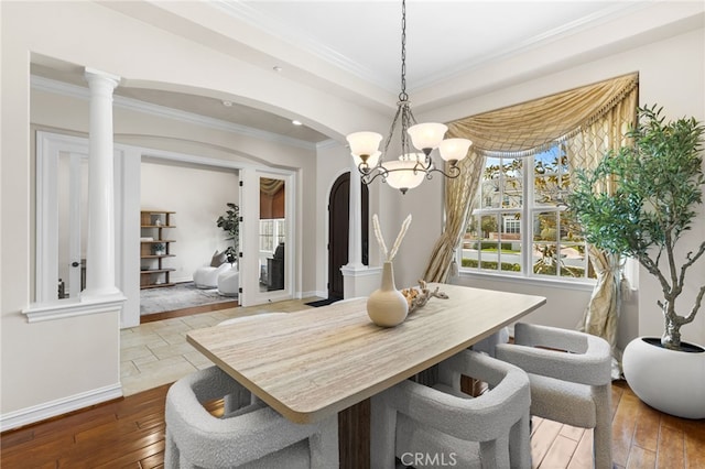 19103 Green Oaks Rd, Yorba Linda, CA 92886 - dining room with crown molding, arched walkways, dark wood-style flooring, a chandelier, and decorative columns