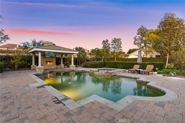 19103 Green Oaks Rd, Yorba Linda, CA 92886 - pool at dusk with a gazebo, a patio area, a pool with connected hot tub, and a warm lit fireplace