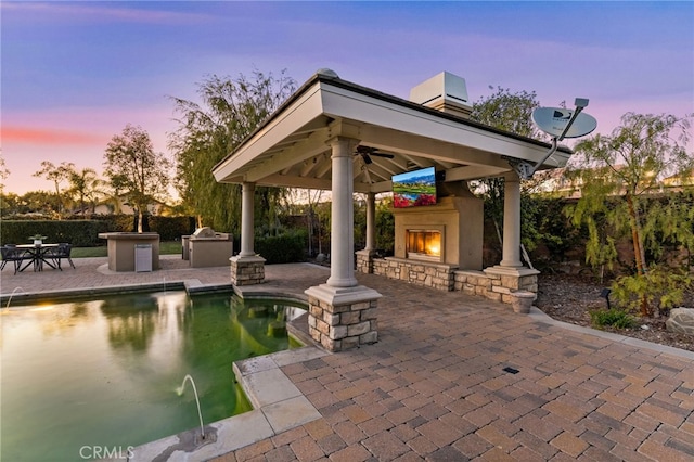 19103 Green Oaks Rd, Yorba Linda, CA 92886 - view of patio / terrace with a gazebo, a lit fireplace, an outdoor kitchen, an outdoor pool, and a ceiling fan
