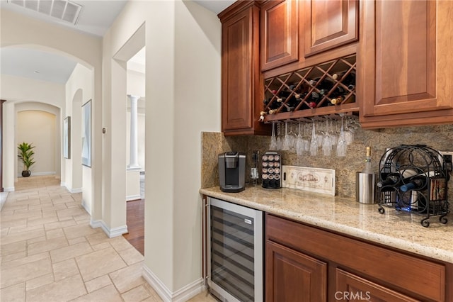 19103 Green Oaks Rd, Yorba Linda, CA 92886 - indoor dry bar with beverage cooler, arched walkways, backsplash, and light stone finish floors