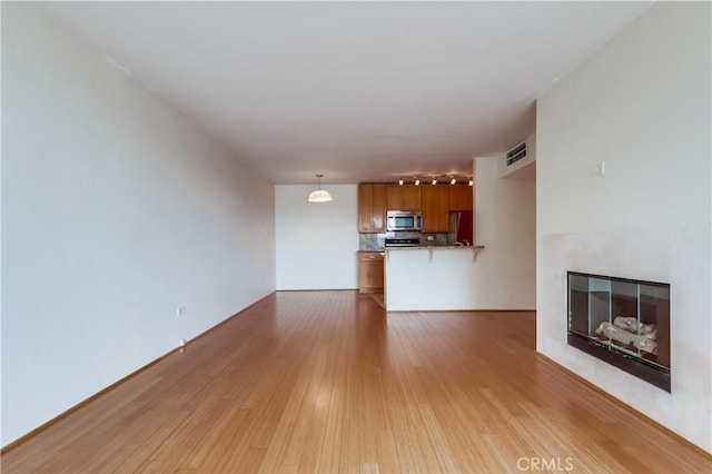 421 S La Fayette Park Pl Unit 701, Los Angeles, CA 90057 - unfurnished living room featuring light wood-type flooring and a fireplace