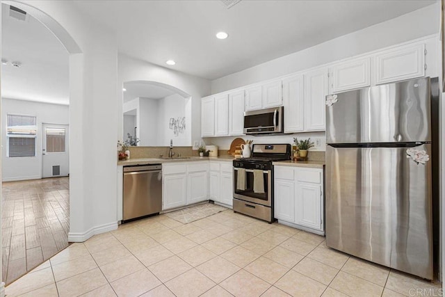 645 Sumner Way Unit 3, Oceanside, CA 92058 - kitchen featuring stainless steel appliances, arched walkways, light countertops, white cabinets, and recessed lighting