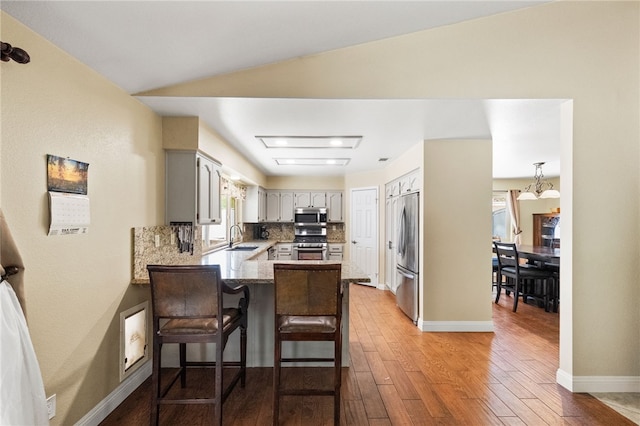 32642 Durango Ct, Wildomar, CA 92595 - kitchen with stainless steel appliances, a sink, a peninsula, and wood-type flooring