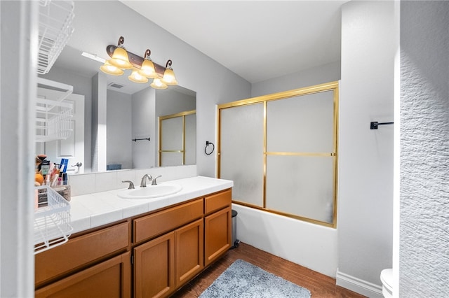 32642 Durango Ct, Wildomar, CA 92595 - bathroom featuring toilet, vanity, wood finished floors, and shower / bath combination with glass door