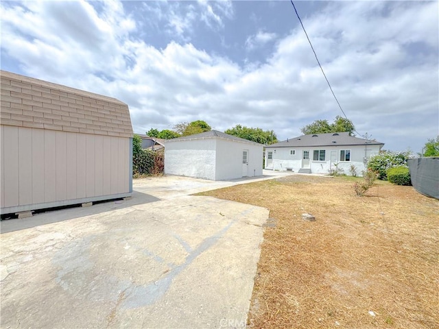 1976 E 112th St, Los Angeles, CA 90059 - back of property with roof with shingles and a patio area