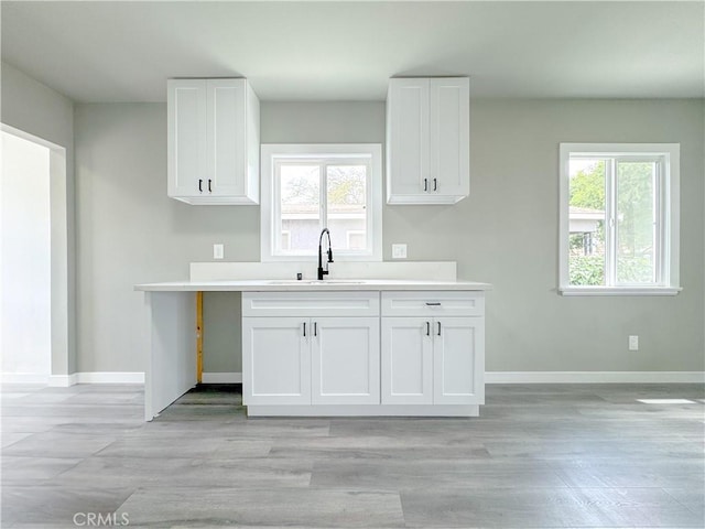 1976 E 112th St, Los Angeles, CA 90059 - kitchen with a sink, baseboards, white cabinetry, and light countertops