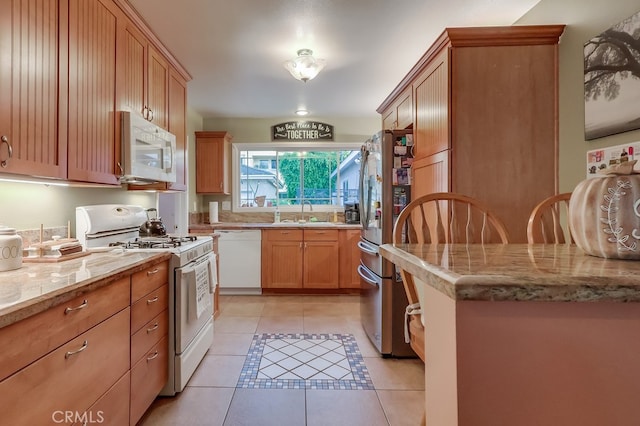 4002 Camerino St, Lakewood, CA 90712 - kitchen with white appliances, light tile patterned floors, light stone counters, and a sink