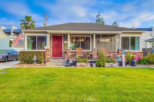 4002 Camerino St, Lakewood, CA 90712 - view of front of home with a front yard, covered porch, board and batten siding, and a shingled roof