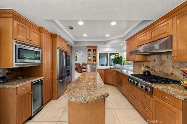 1738 N Ukiah Way, Upland, CA 91784 - kitchen featuring appliances with stainless steel finishes, under cabinet range hood, wine cooler, a kitchen island, and tasteful backsplash