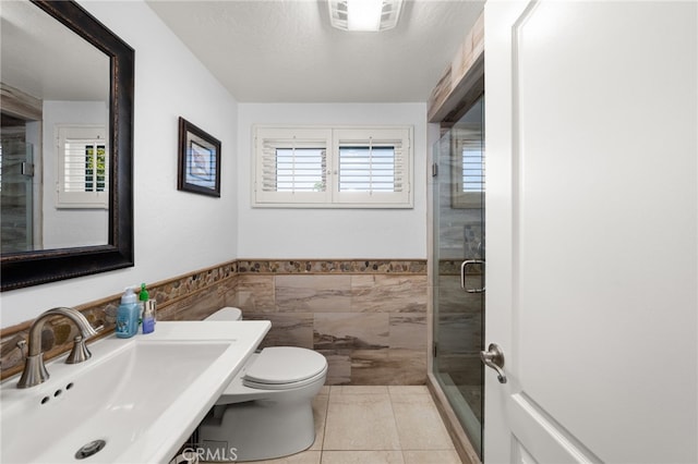 1738 N Ukiah Way, Upland, CA 91784 - full bathroom featuring a sink, toilet, a stall shower, tile walls, and wainscoting