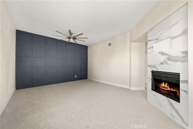 31832 Poole Ct, Temecula, CA 92591 - unfurnished living room with a decorative wall, ceiling fan, a high end fireplace, carpet floors, and baseboards