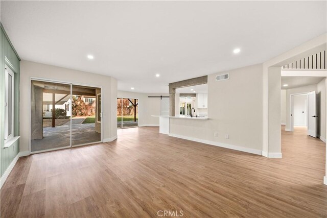 31832 Poole Ct, Temecula, CA 92591 - unfurnished living room featuring a sink, light wood-style flooring, recessed lighting, and baseboards