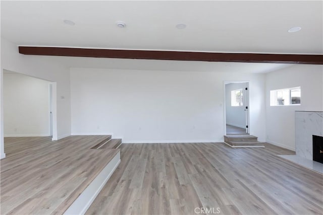 1342 W Magnolia St, Compton, CA 90220 - unfurnished living room featuring beam ceiling, light wood-style floors, a high end fireplace, and baseboards