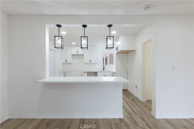 1342 W Magnolia St, Compton, CA 90220 - kitchen featuring white cabinetry, a peninsula, a sink, light wood finished floors, and recessed lighting