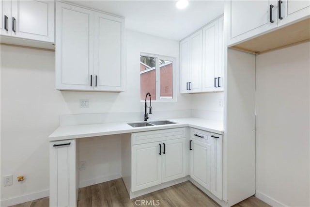 1342 W Magnolia St, Compton, CA 90220 - kitchen with a sink, light wood-type flooring, white cabinetry, and light countertops