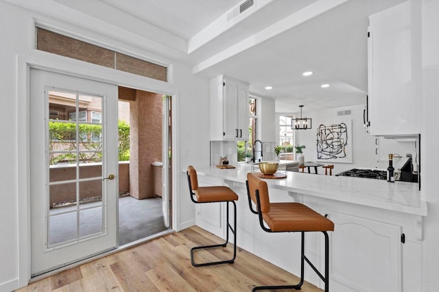3581 Cameo Dr Unit 35, Oceanside, CA 92056 - kitchen with light wood-type flooring, white cabinets, recessed lighting, light countertops, and healthy amount of natural light
