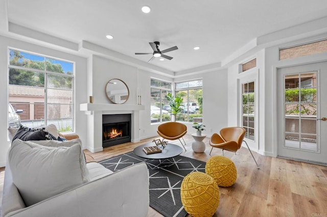 3581 Cameo Dr Unit 35, Oceanside, CA 92056 - living area featuring a tray ceiling, wood finished floors, ceiling fan, a warm lit fireplace, and recessed lighting