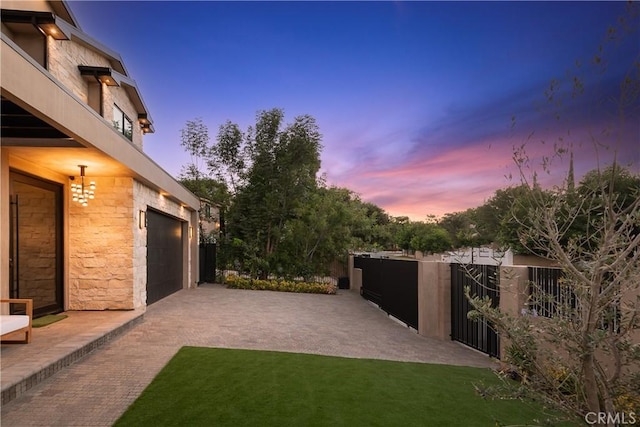 16828 Otsego St, Encino, CA 91436 - yard at dusk with a garage, a balcony, and driveway