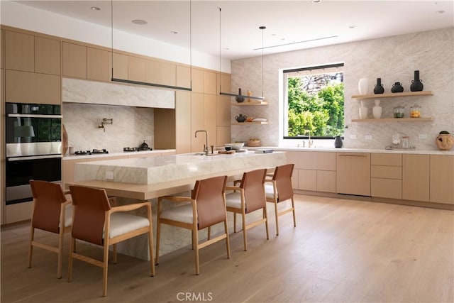 16828 Otsego St, Encino, CA 91436 - kitchen featuring open shelves, stainless steel double oven, decorative backsplash, and a kitchen breakfast bar