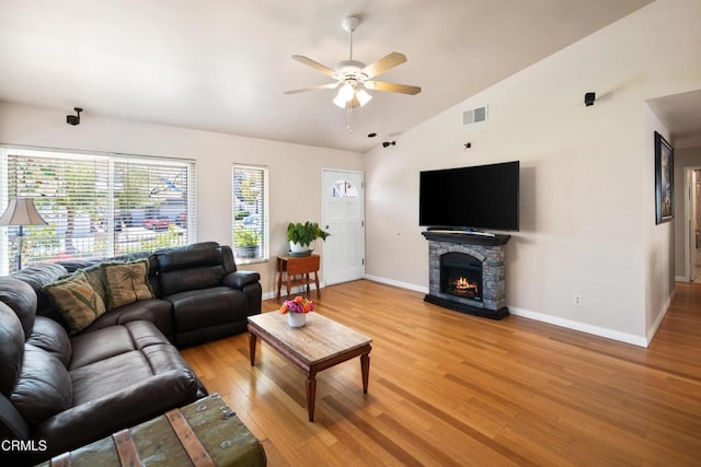 27585 Pamplico Dr, Valencia, CA 91354 - living room featuring lofted ceiling, a ceiling fan, baseboards, light wood-style flooring, and a stone fireplace