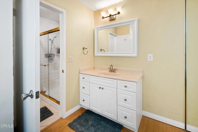 27585 Pamplico Dr, Valencia, CA 91354 - full bathroom with a stall shower, vanity, wood finished floors, and baseboards