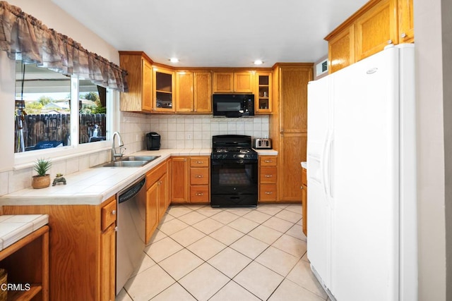 27585 Pamplico Dr, Valencia, CA 91354 - kitchen with black appliances, a sink, tile countertops, brown cabinets, and decorative backsplash