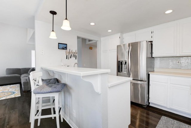 11855 Caminito Ronaldo Unit 108, San Diego, CA 92128 - kitchen featuring stainless steel refrigerator with ice dispenser, dark wood finished floors, a breakfast bar, white cabinetry, and recessed lighting