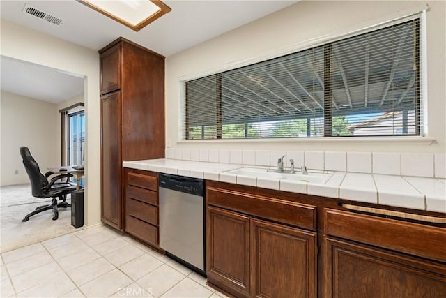 42330 61st St W, Lancaster, CA 93536 - kitchen with dishwasher, a sink, tile counters, light tile patterned floors, and light colored carpet