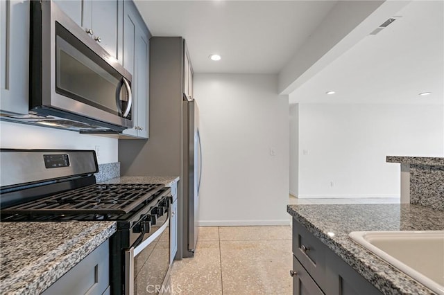 4612 W 132nd St, Hawthorne, CA 90250 - kitchen featuring stainless steel appliances, gray cabinets, baseboards, dark speckled floor, and stone counters