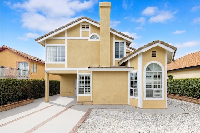14121 Exeter Ct, Fontana, CA 92336 - rear view of property featuring stucco siding, a patio, a chimney, and a tiled roof