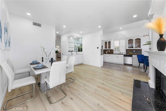 14121 Exeter Ct, Fontana, CA 92336 - dining room with light wood-type flooring, recessed lighting, a high end fireplace, and baseboards