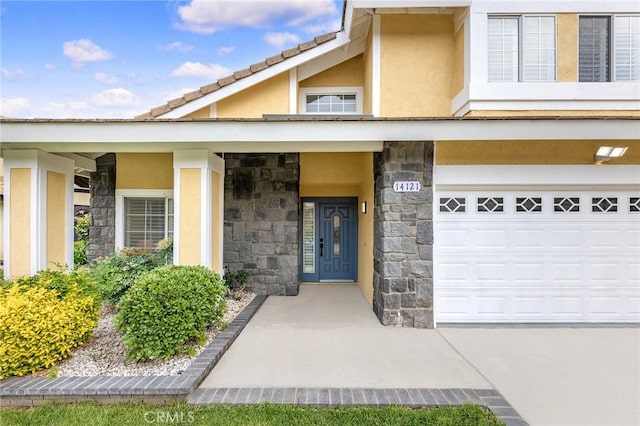 14121 Exeter Ct, Fontana, CA 92336 - doorway to property featuring stone siding, stucco siding, and a garage