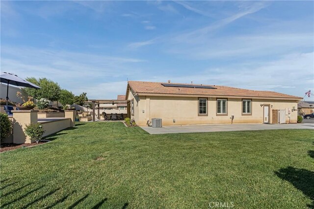 29042 Botanical Cir, Menifee, CA 92584 - rear view of property featuring roof mounted solar panels, a patio, stucco siding, a yard, and central AC