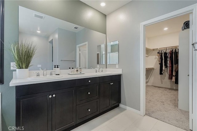 29042 Botanical Cir, Menifee, CA 92584 - bathroom featuring double vanity, a spacious closet, tile patterned flooring, baseboards, and recessed lighting