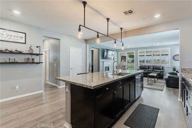 29042 Botanical Cir, Menifee, CA 92584 - kitchen with a sink, dark cabinetry, light wood-type flooring, dishwasher, and open floor plan