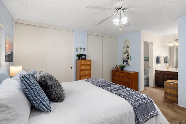 7780 Parkway Dr Unit 703, La Mesa, CA 91942 - carpeted bedroom with two closets, a textured ceiling, a ceiling fan, and connected bathroom