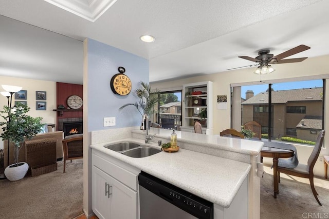 7780 Parkway Dr Unit 703, La Mesa, CA 91942 - kitchen with stainless steel dishwasher, a sink, light colored carpet, a fireplace, and light countertops