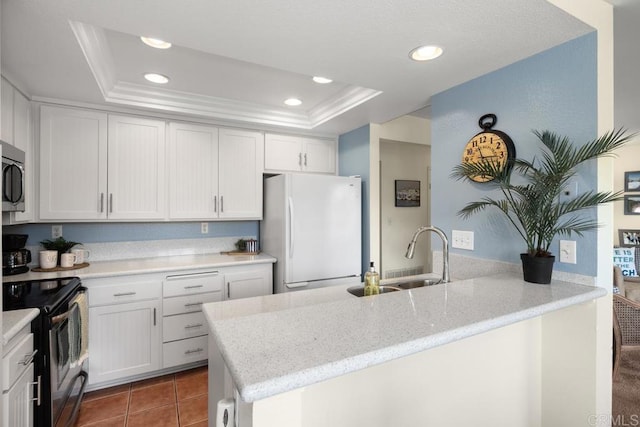 7780 Parkway Dr Unit 703, La Mesa, CA 91942 - kitchen featuring appliances with stainless steel finishes, a tray ceiling, a sink, a peninsula, and recessed lighting