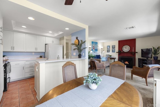 7780 Parkway Dr Unit 703, La Mesa, CA 91942 - dining space with a large fireplace, a tray ceiling, ceiling fan, light tile patterned flooring, and recessed lighting