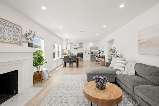 453 N Walker Ave, San Pedro, CA 90732 - living area featuring light wood-type flooring, recessed lighting, and a fireplace with flush hearth