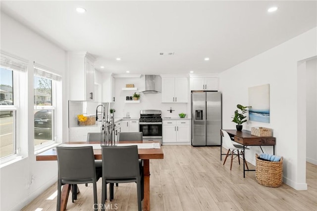 453 N Walker Ave, San Pedro, CA 90732 - kitchen with appliances with stainless steel finishes, wall chimney exhaust hood, white cabinetry, recessed lighting, and light wood finished floors