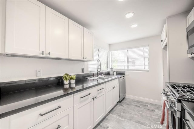 46 Echo Run Unit 16, Irvine, CA 92614 - kitchen featuring stainless steel appliances, a sink, baseboards, white cabinets, and recessed lighting