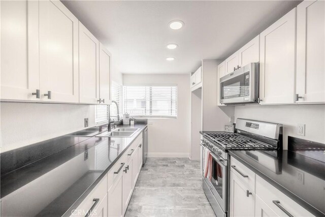 46 Echo Run Unit 16, Irvine, CA 92614 - kitchen with appliances with stainless steel finishes, a sink, baseboards, recessed lighting, and dark countertops