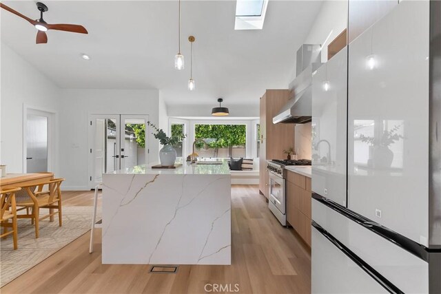 2011 Reynosa Dr, Torrance, CA 90501 - kitchen featuring stainless steel stove, freestanding refrigerator, modern cabinets, a center island, and wall chimney range hood