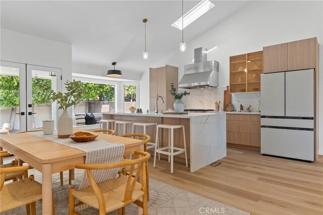 2011 Reynosa Dr, Torrance, CA 90501 - kitchen featuring freestanding refrigerator, wall chimney exhaust hood, a skylight, modern cabinets, and light wood finished floors