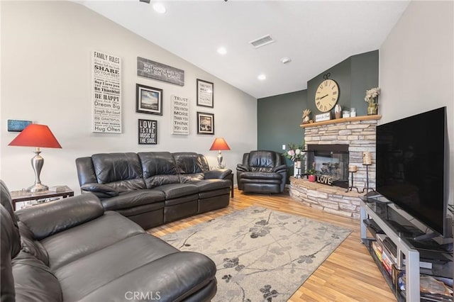 27141 Calle Ayrton, Menifee, CA 92586 - living room featuring vaulted ceiling, wood finished floors, a stone fireplace, and recessed lighting