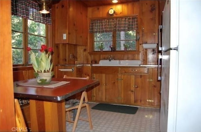 29053 Cedar Ter, Lake Arrowhead, CA 92321 - kitchen featuring freestanding refrigerator, brown cabinets, wooden walls, and light countertops