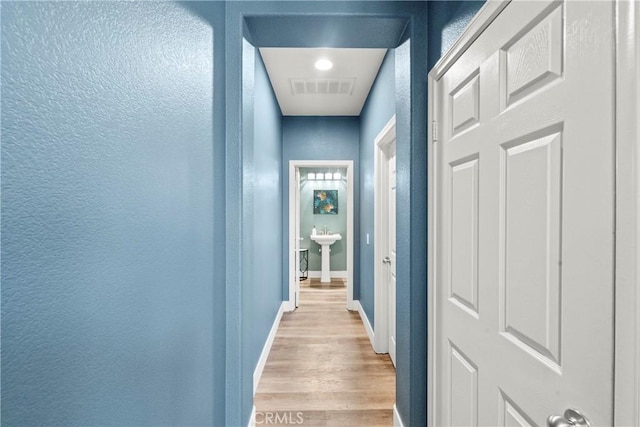 29889 Warm Sands Dr, Menifee, CA 92584 - corridor featuring a textured wall, light wood-style floors, and baseboards
