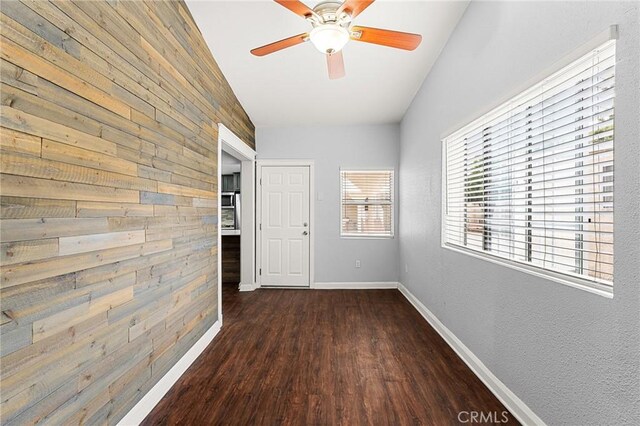 1040 W 3rd St, Pomona, CA 91766 - corridor with wooden walls, dark wood-style flooring, and baseboards